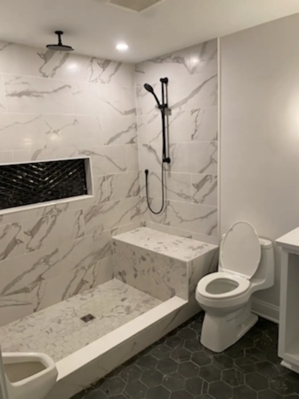 Remodeled bathroom with a tiled shower and toilet