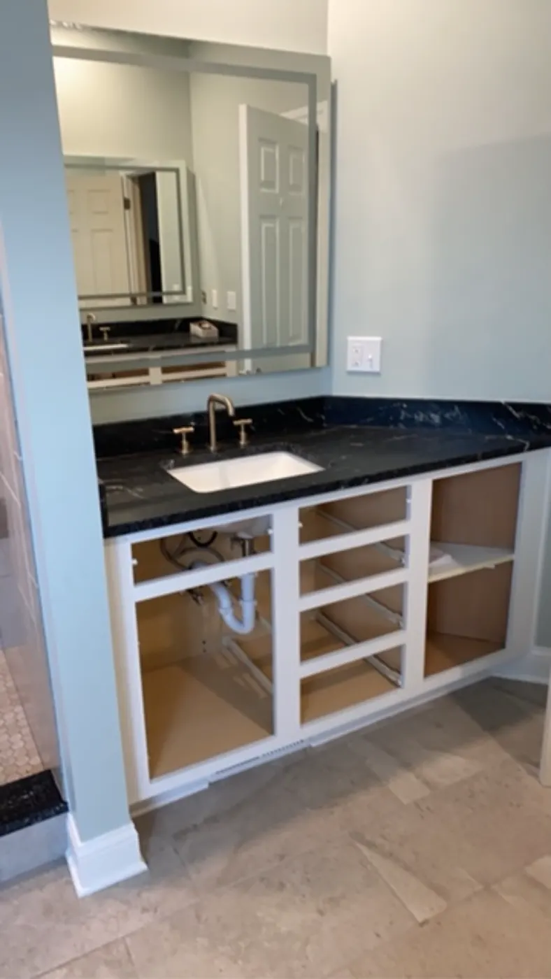 New vanity with a black stone top and undermount sink