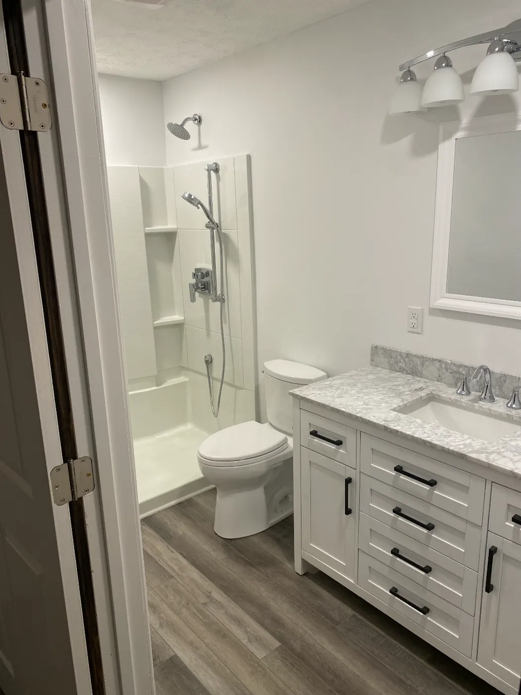 Remodeled bathroom with a white vanity and tub-shower