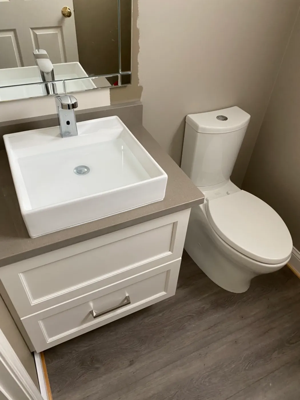 Powder room with a vessel sink and new toilet