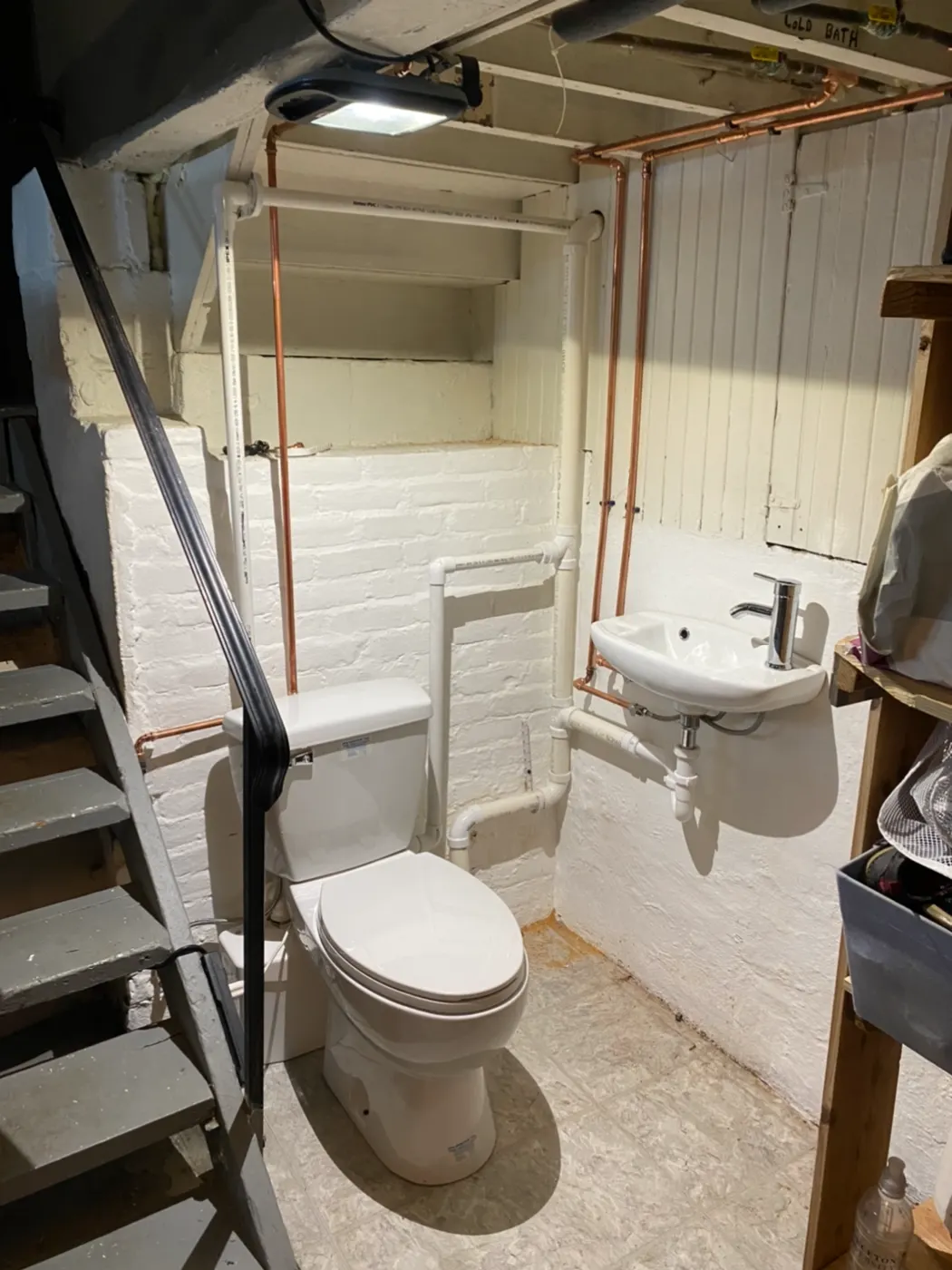 Basement bathroom with a toilet and wall-hung sink